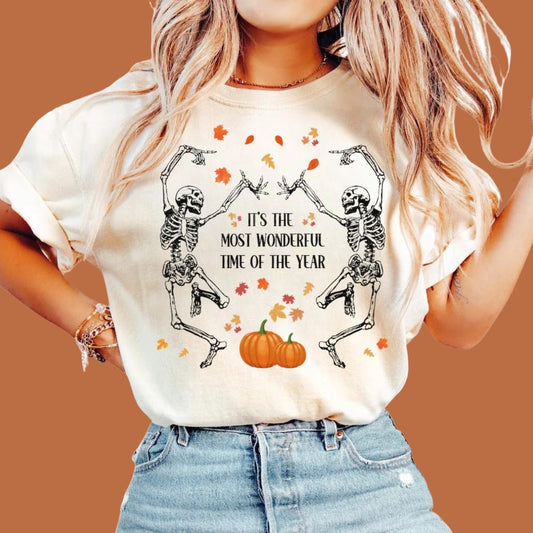 Dancing Skeletons Halloween t-shirt in white with two skeletons dancing under falling leaves around two pumpkins - Any Gift for You