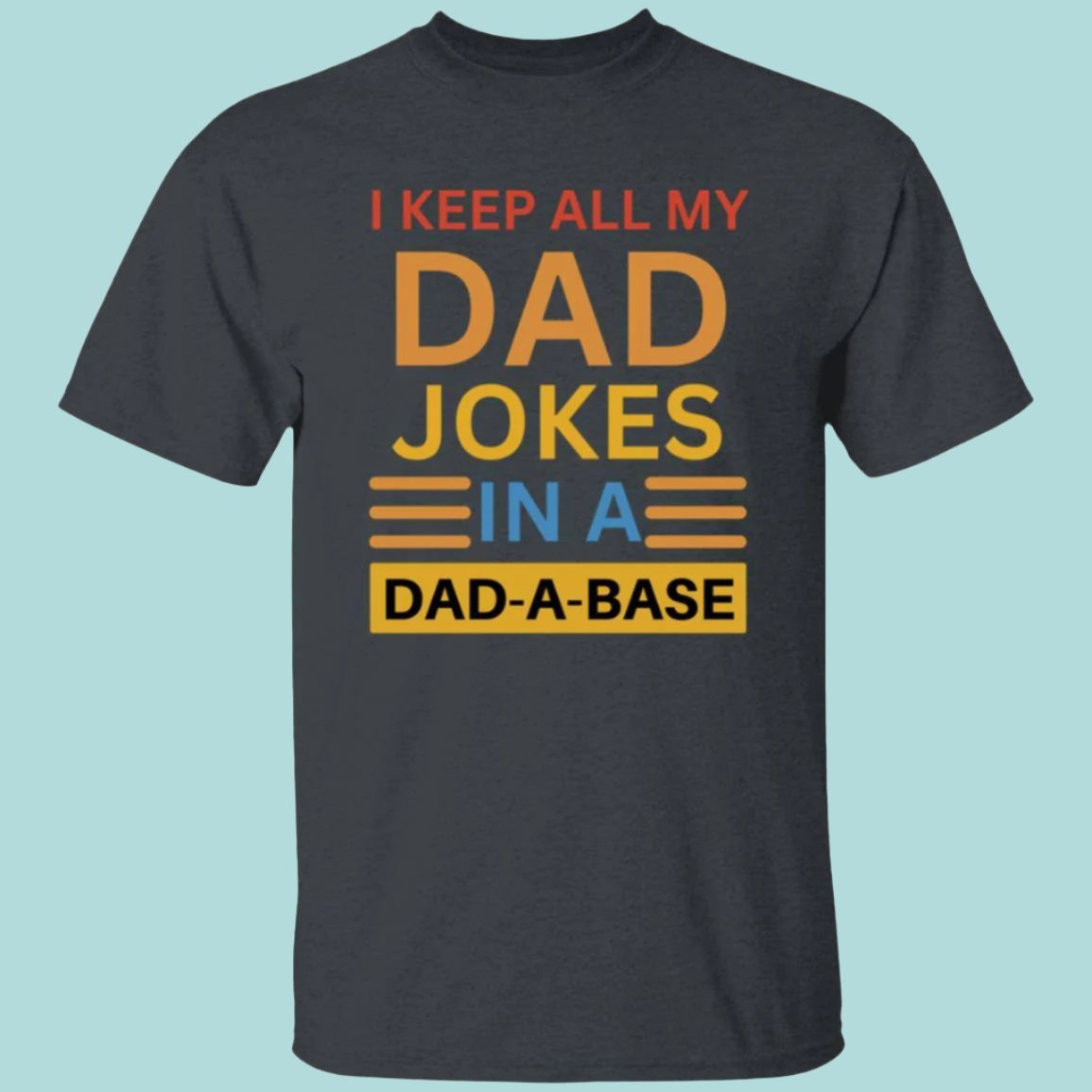 Dark heather gray, heavyweight classic unisex t-shirt in 100% cotton. On the front is printed: I keep all my DAD jokes in a DAD-A-BASE - Any Gift For You